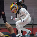 המילטון כפסל על מכסה חלק הקדמי של מכונית המרצדס, חוגג נצחון נוסף