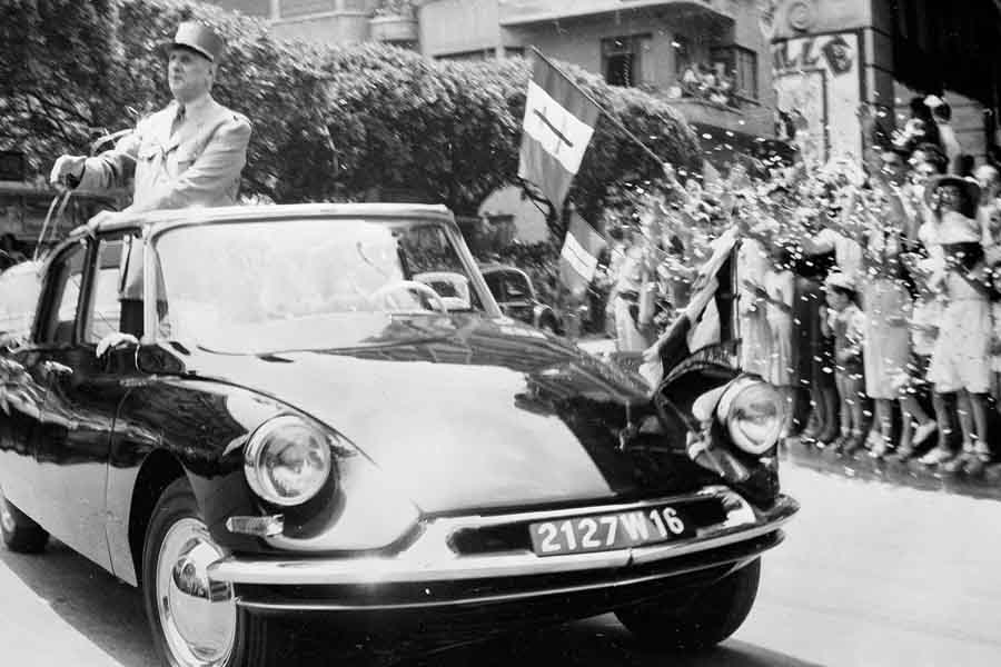 שארל דה גול בסיטרואן DS נשיאותית וללא גג מתנשא גבוה מעל למסגרת הגג